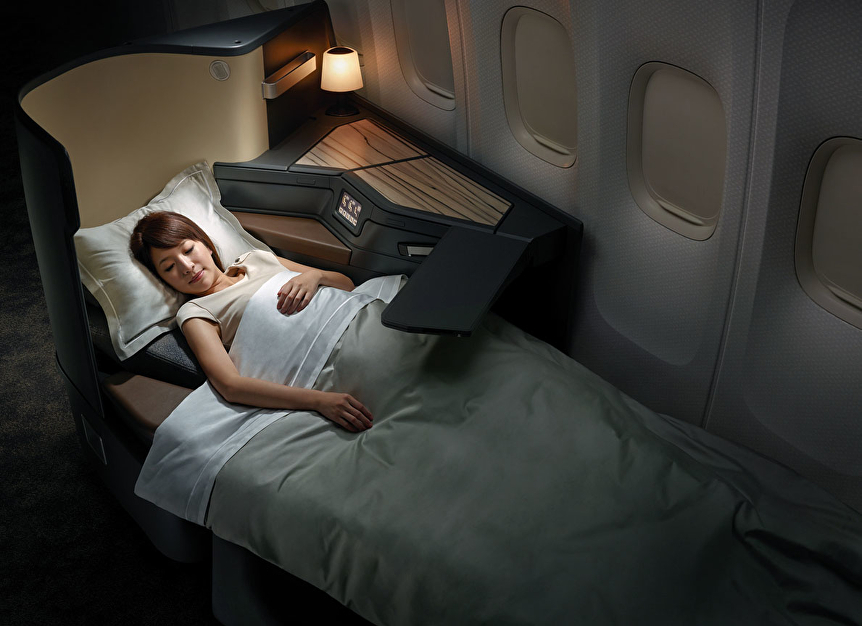 a woman laying in a bed on an airplane