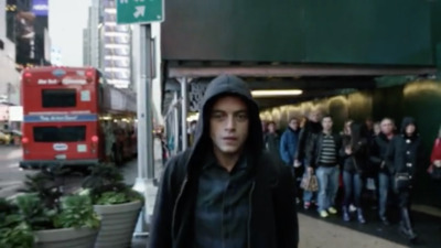 a man in a hooded jacket walking down a street