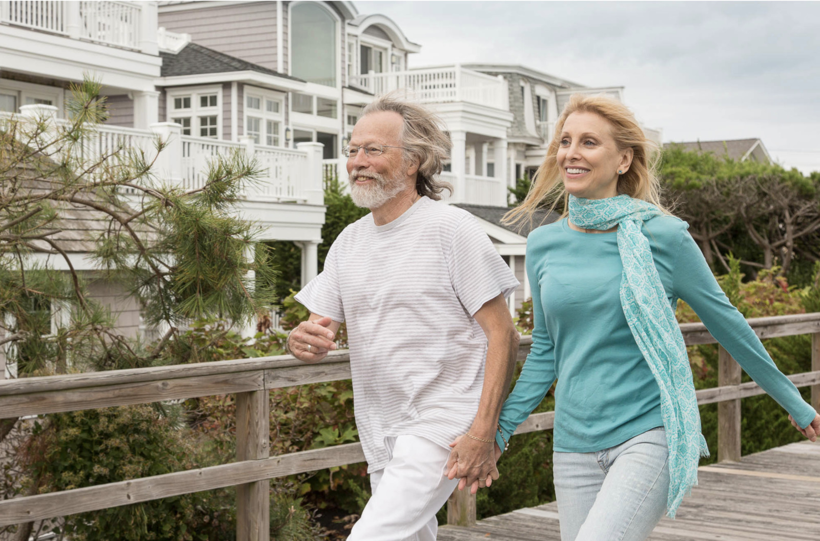 a man and a woman walking on a boardwalk