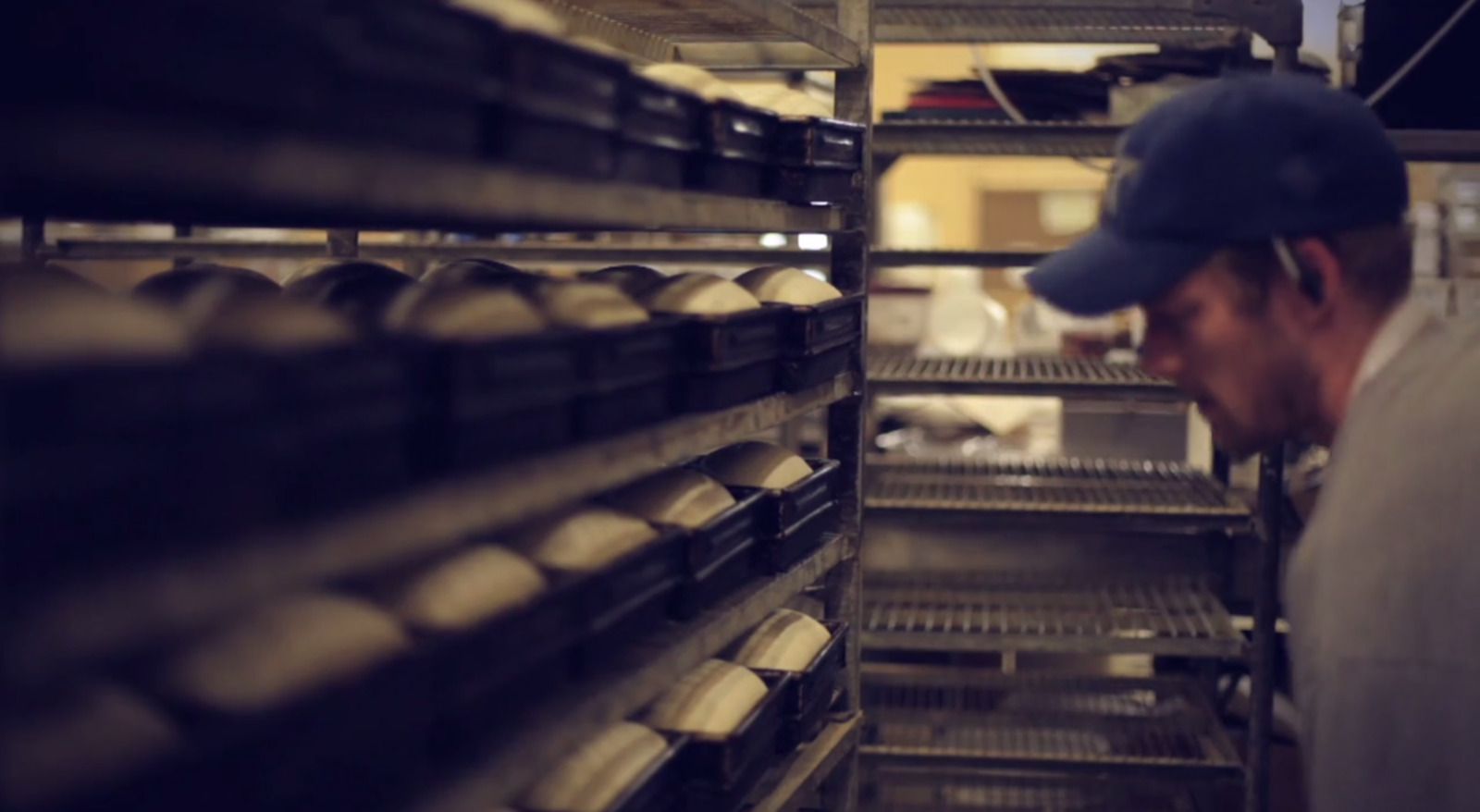 a man looking at a rack of baked goods