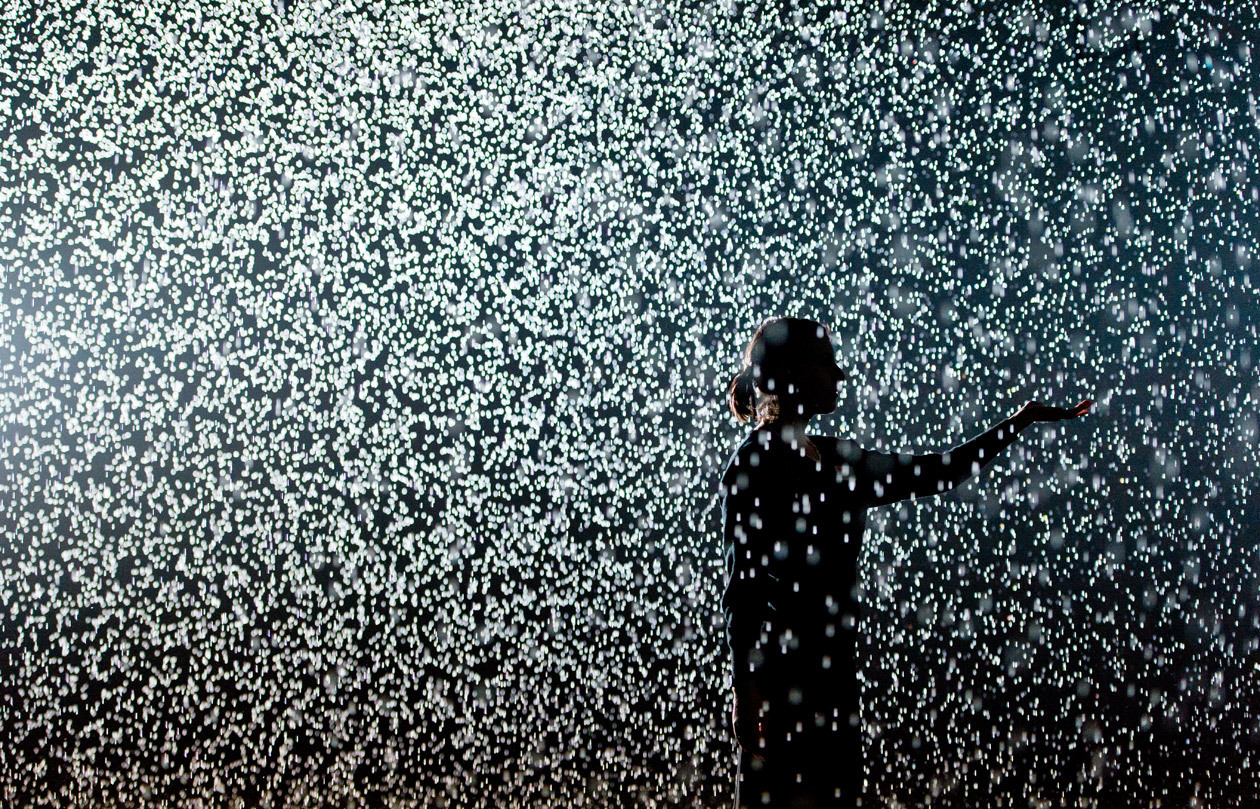 a person standing in the rain with an umbrella