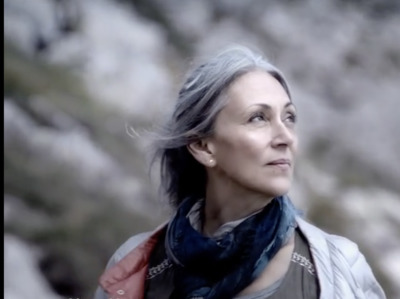 a woman with grey hair wearing a scarf