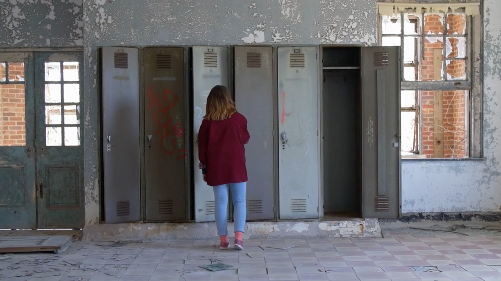 a woman standing in front of a row of lockers