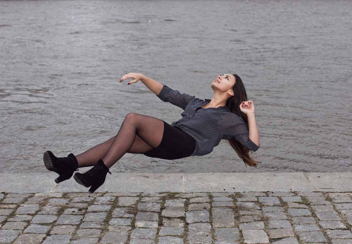 a woman in tights and a shirt is jumping in the air