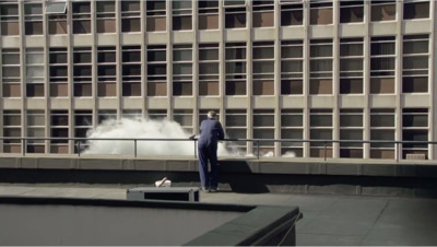 a man in a blue suit standing on a balcony