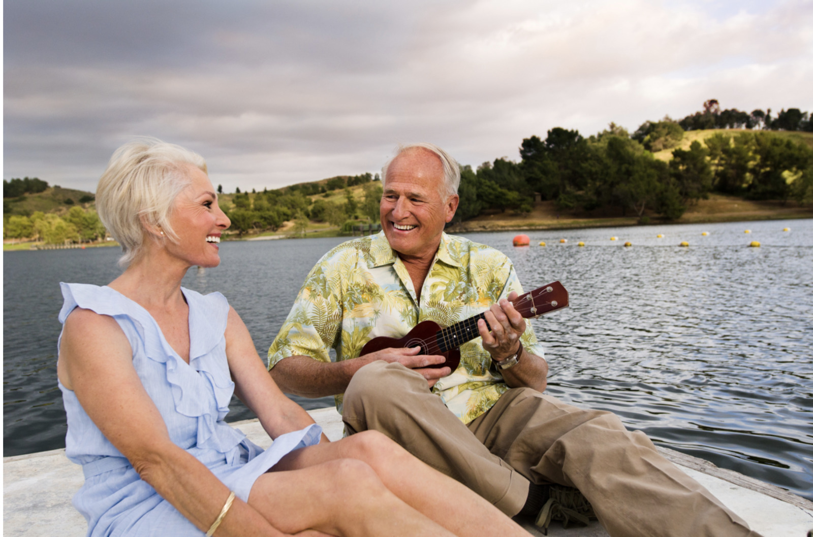 a man and woman sitting on a boat playing a guitar