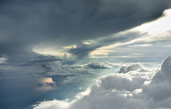 a plane flying through a cloudy sky