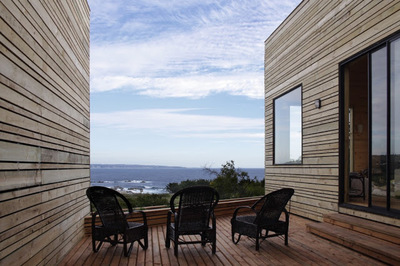 a couple of chairs sitting on top of a wooden deck