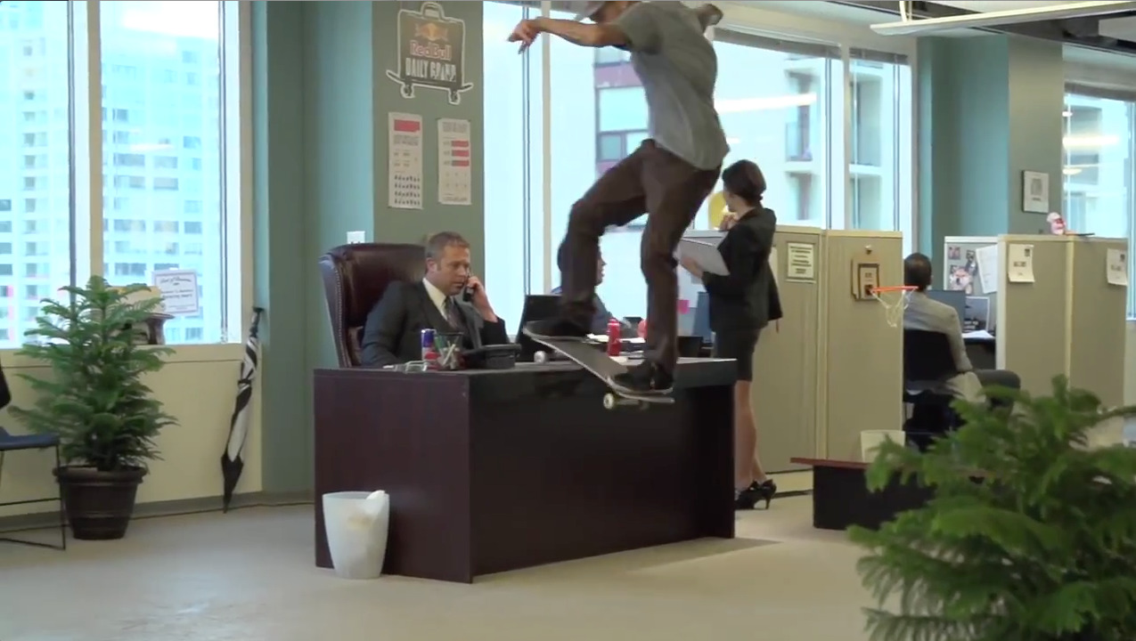 a man riding a skateboard on top of a desk
