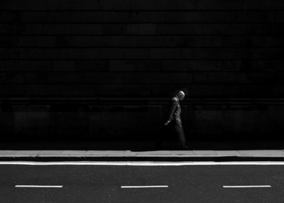 a man walking down a street next to a building