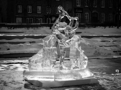 a statue of a woman holding a bird on top of ice