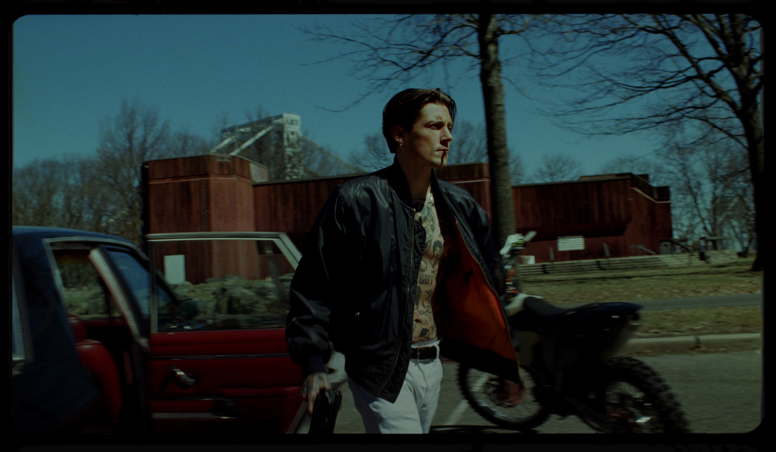 a man standing next to a motorcycle on a street