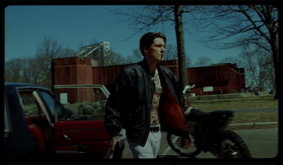 a man standing next to a motorcycle on a street