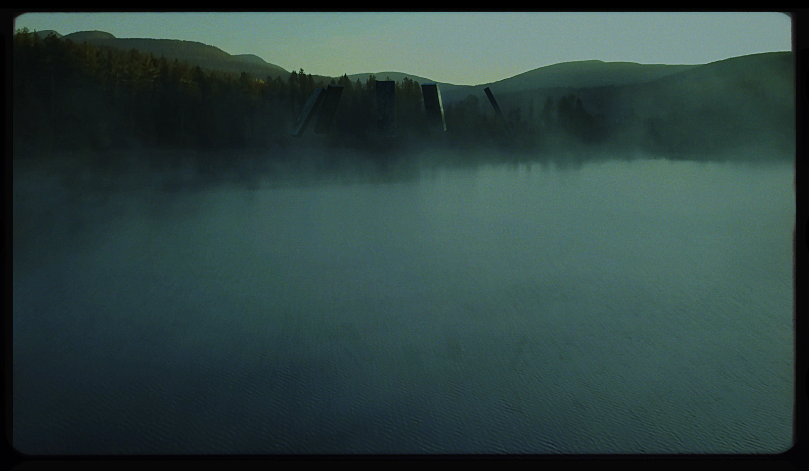 a body of water surrounded by mountains and trees