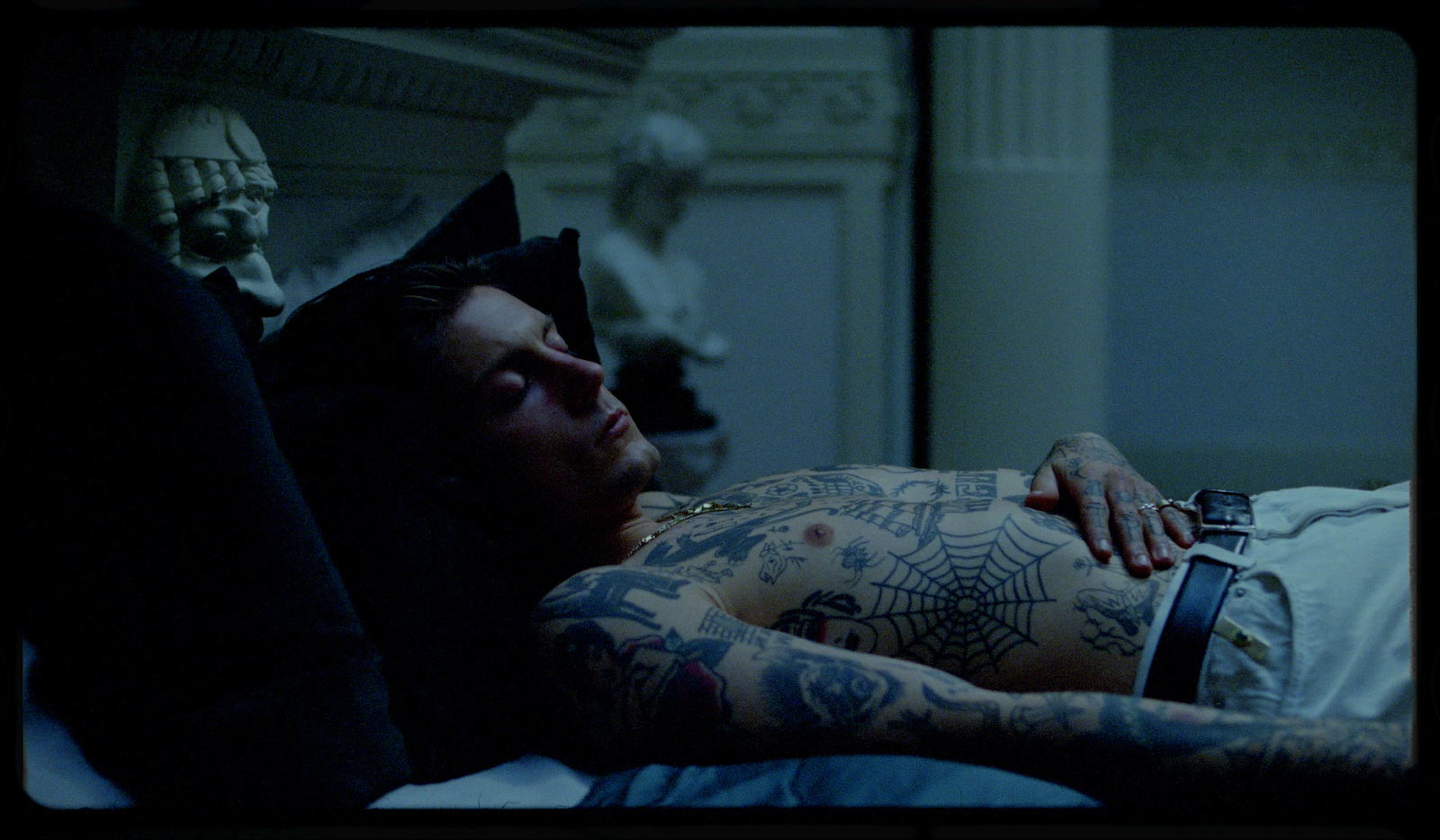 a man with tattoos laying on a bed