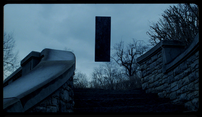 a dark picture of a stone staircase and a sign