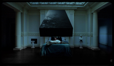 a person laying in a bed in a dark room