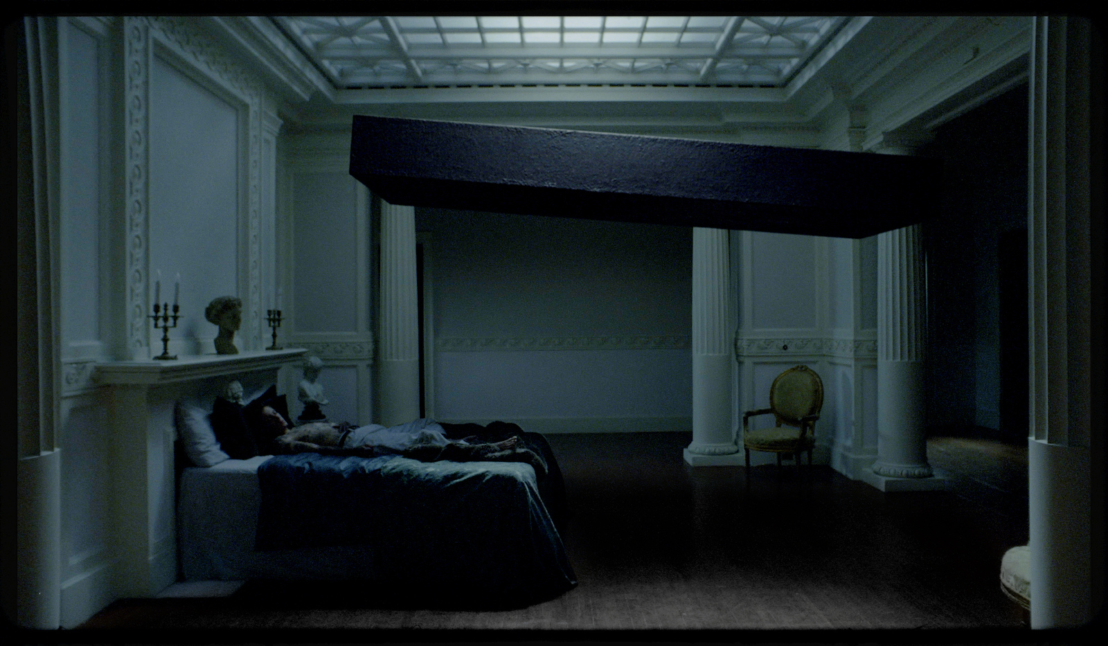 a person laying on a bed in a dimly lit room