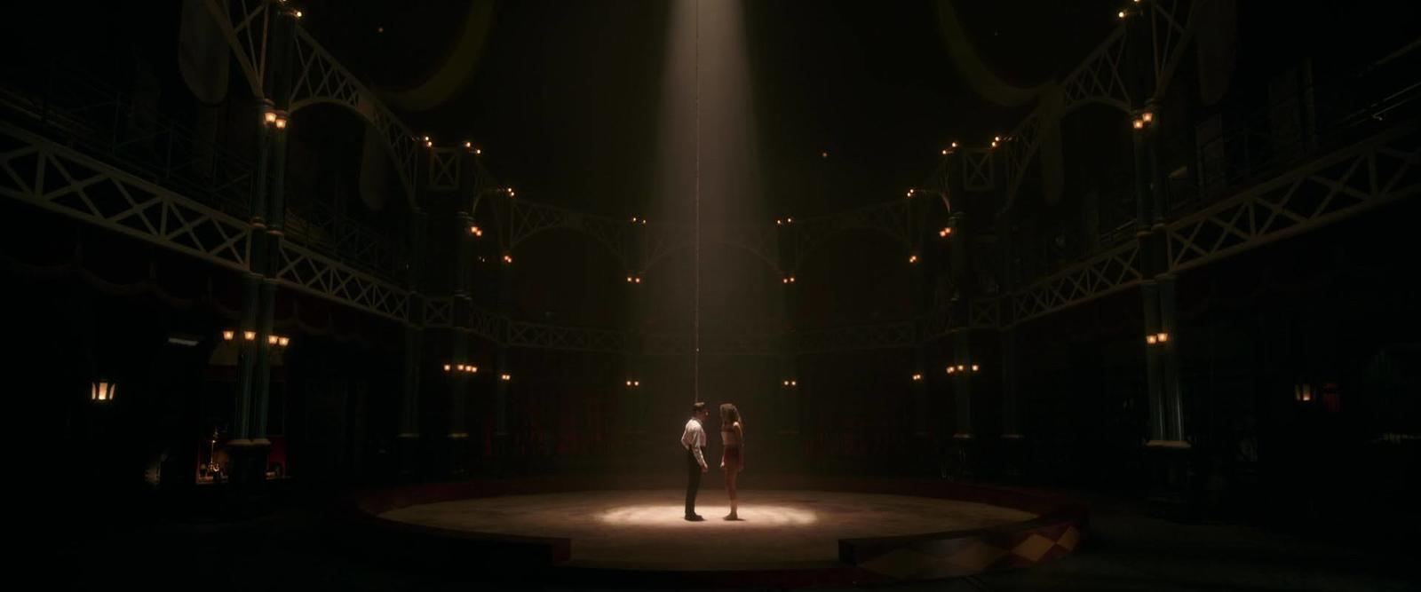 two people standing on a stage in the dark