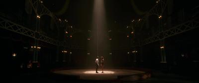 two people standing on a stage in the dark