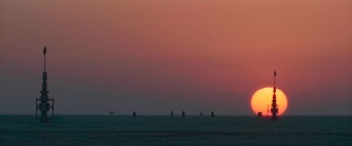 the sun is setting over the horizon of a field