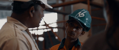 two men wearing hard hats in a factory