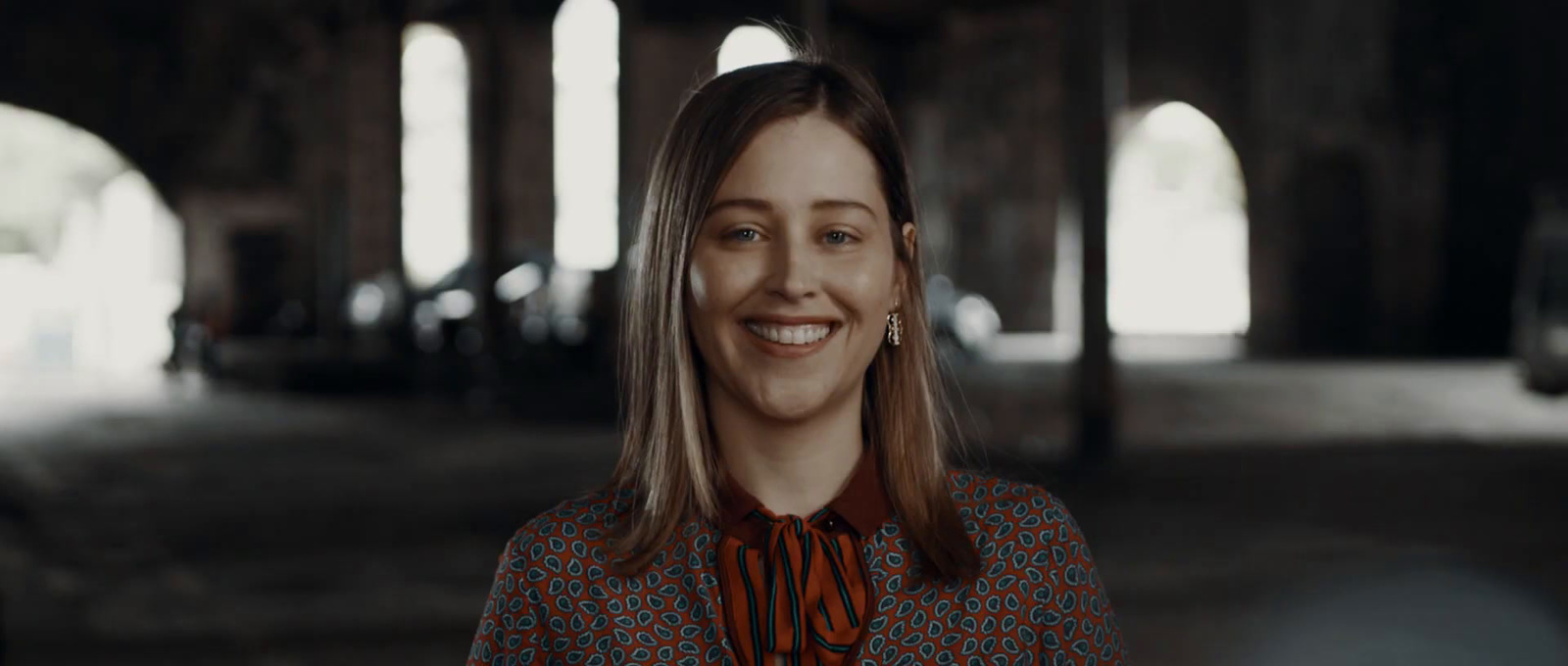 a woman is smiling and wearing a tie