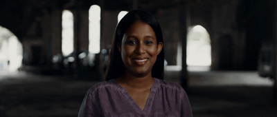 a woman standing in a dark room with arches