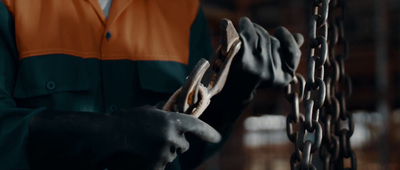 a person in a green and orange shirt holding a piece of wood