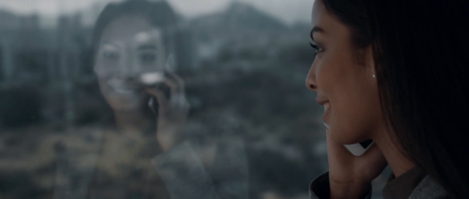 a woman talking on a cell phone in front of a window