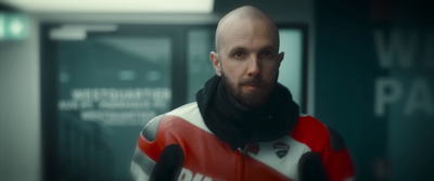 a man with a bald head wearing a red and white jacket