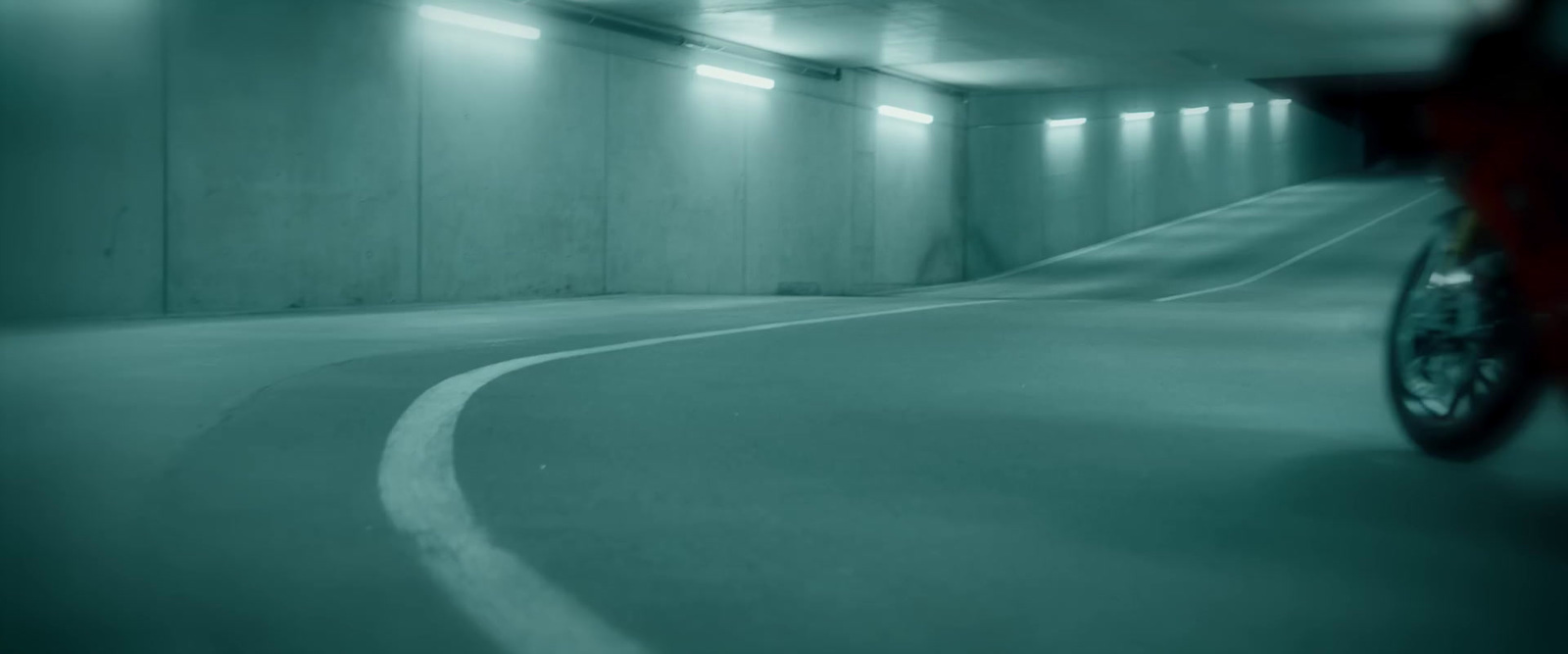 a person riding a bike in a parking garage