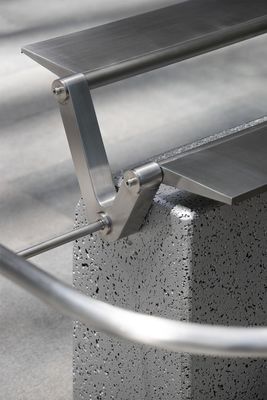 a metal bench sitting on top of a cement block