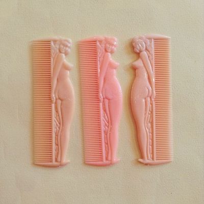 a couple of pink combs sitting on top of a table