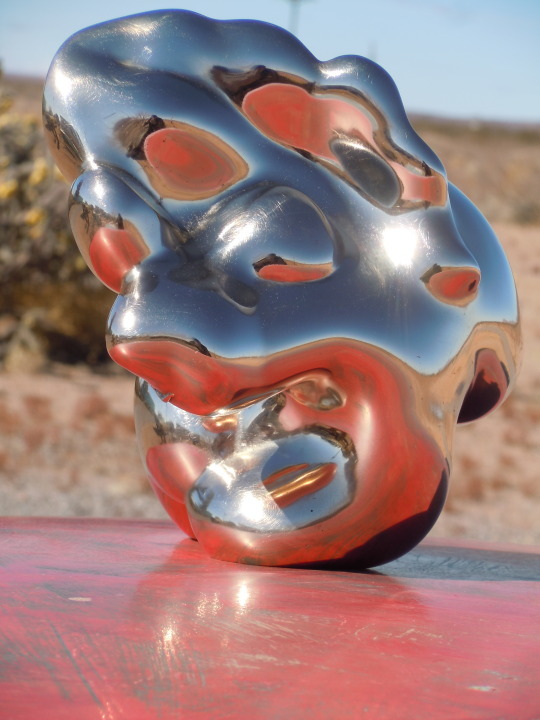 a metal mask sitting on top of a red table