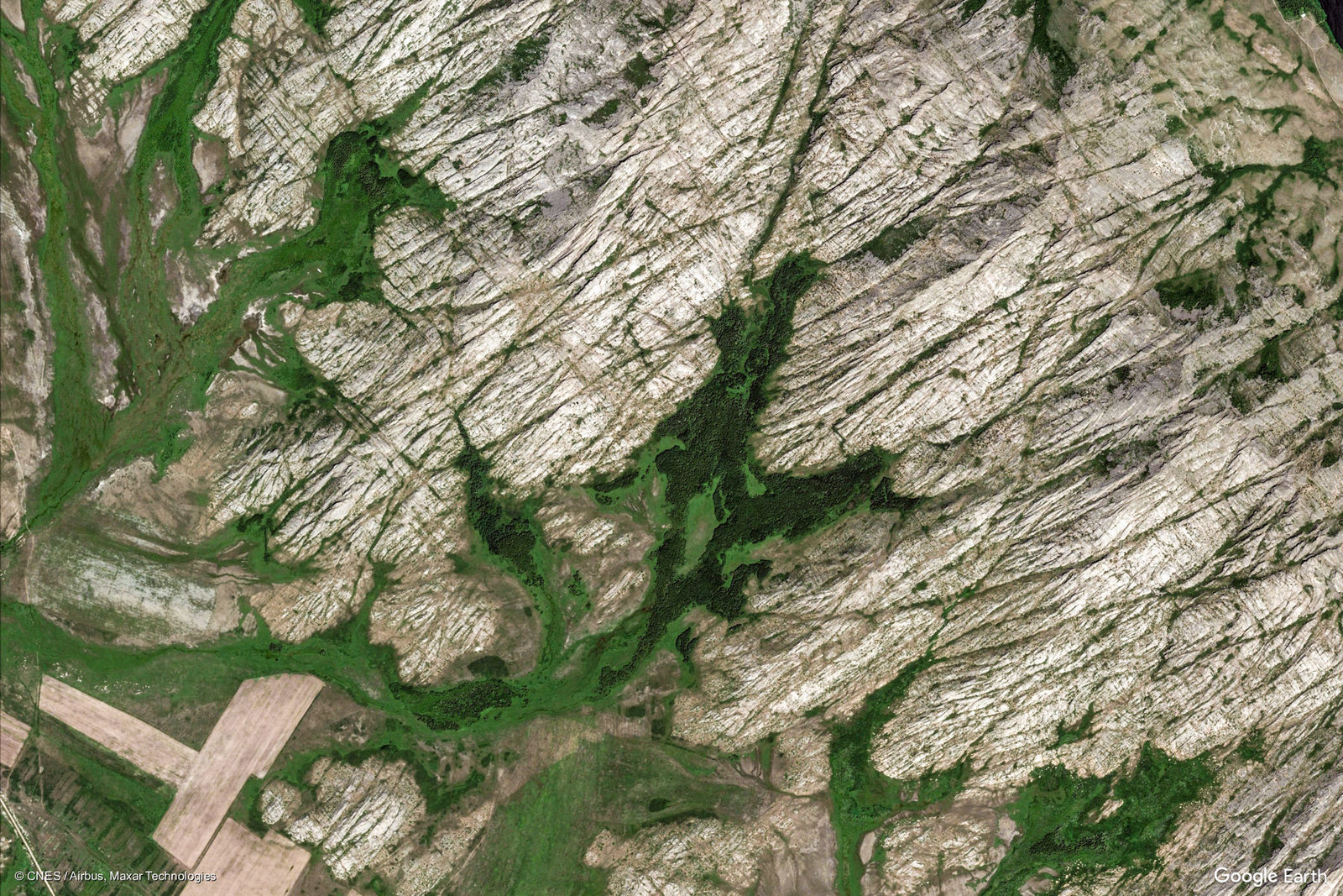 an aerial view of a mountain with green vegetation