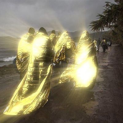 a group of people walking down a road next to the ocean