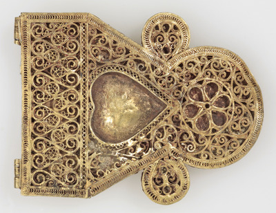 a gold brooch with a heart in the center