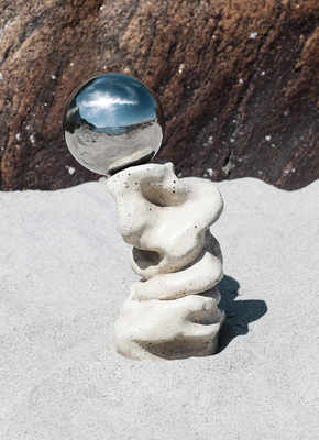 a sculpture of a rock and a ball on top of it