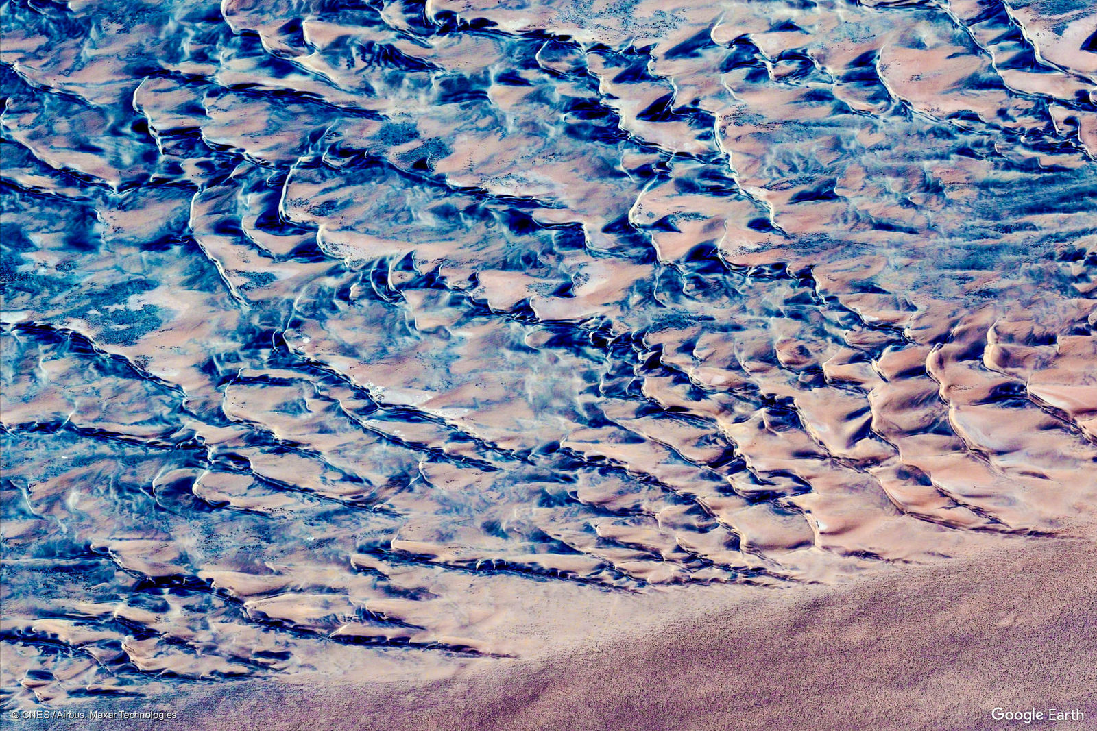 an aerial view of a sandy beach with waves