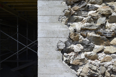 a close up of a stone wall with scaffolding in the background