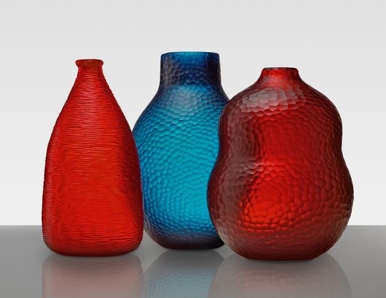 three different colored vases sitting next to each other