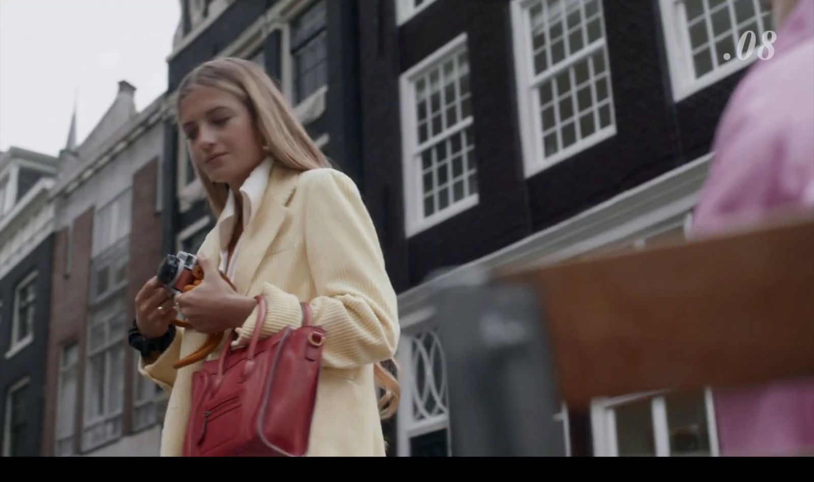 a woman standing in front of a building looking at her cell phone