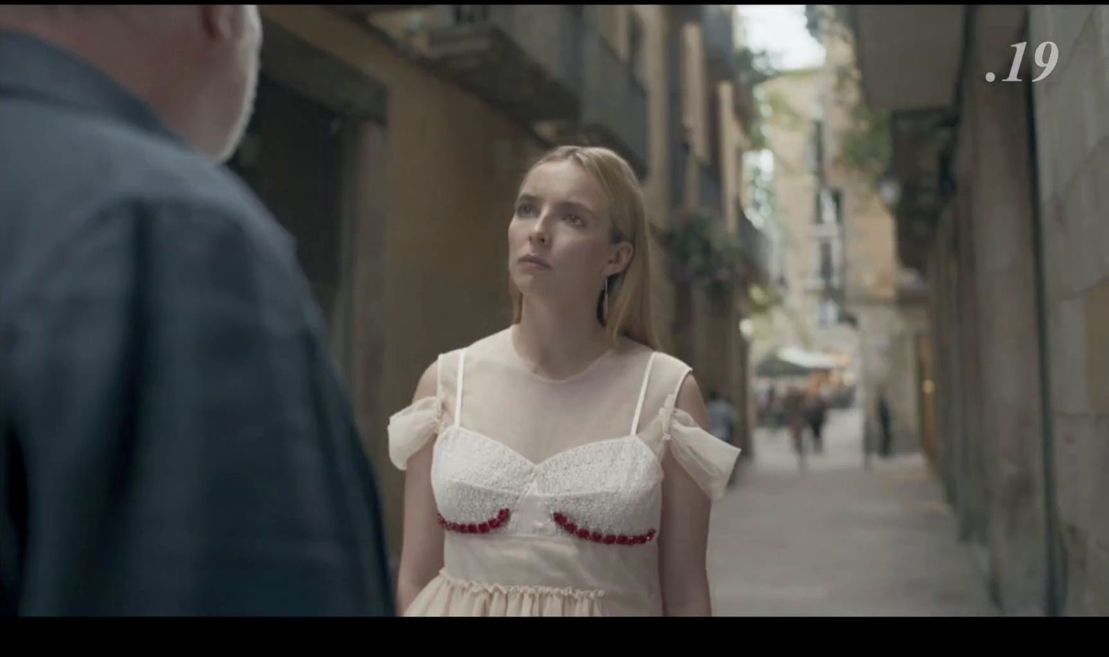 a woman in a white dress standing next to a man