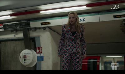 a woman is standing in a subway station