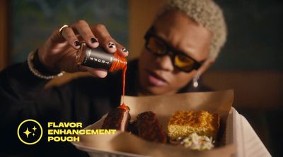 a woman pouring sauce on a tray of food