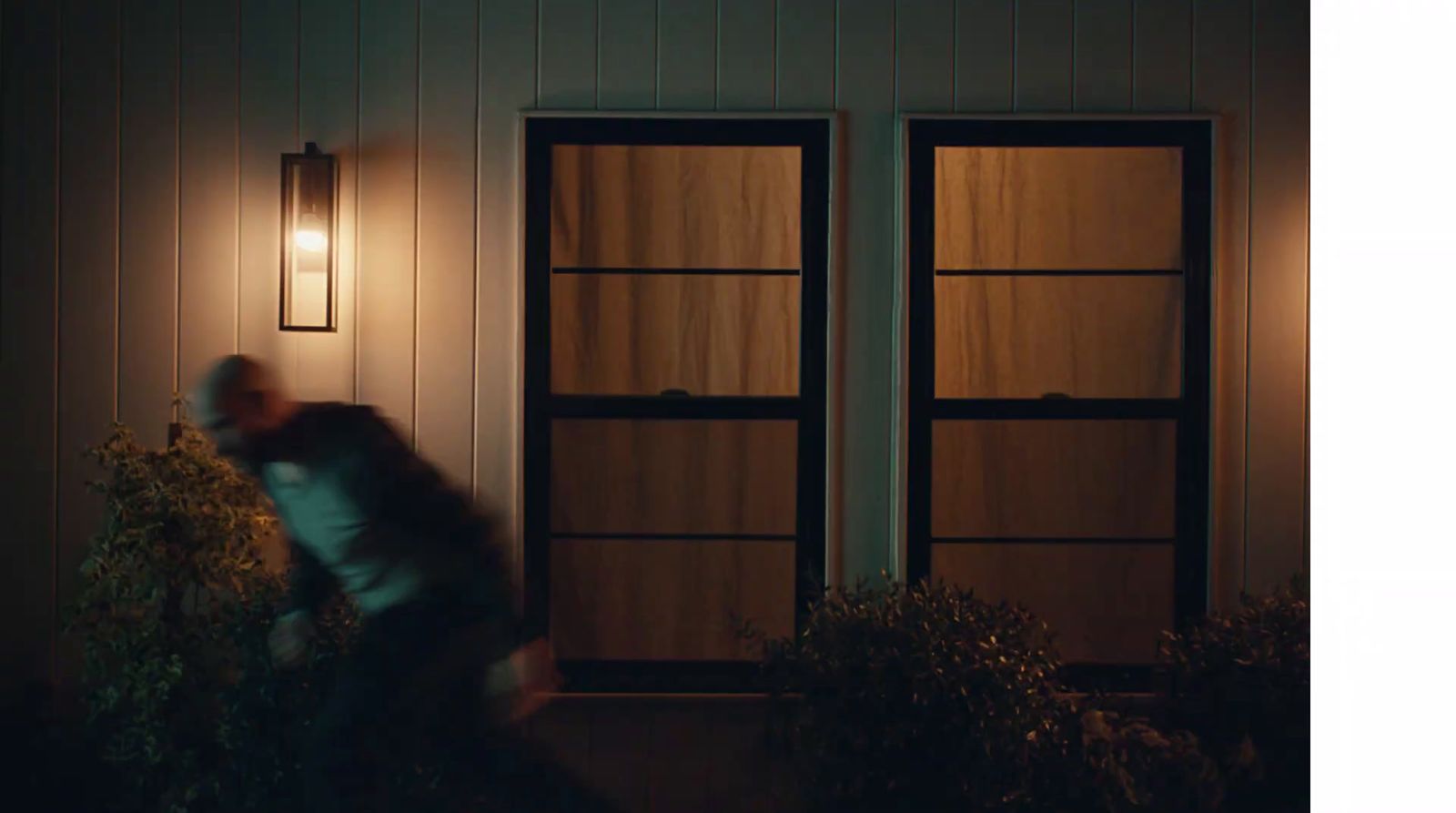 a person standing outside of a house at night