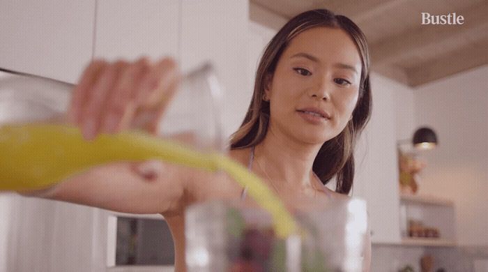 a woman pouring a drink into a glass