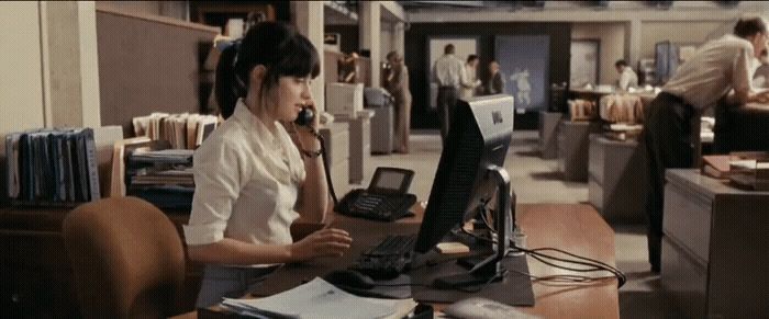 a woman sitting at a desk with a computer