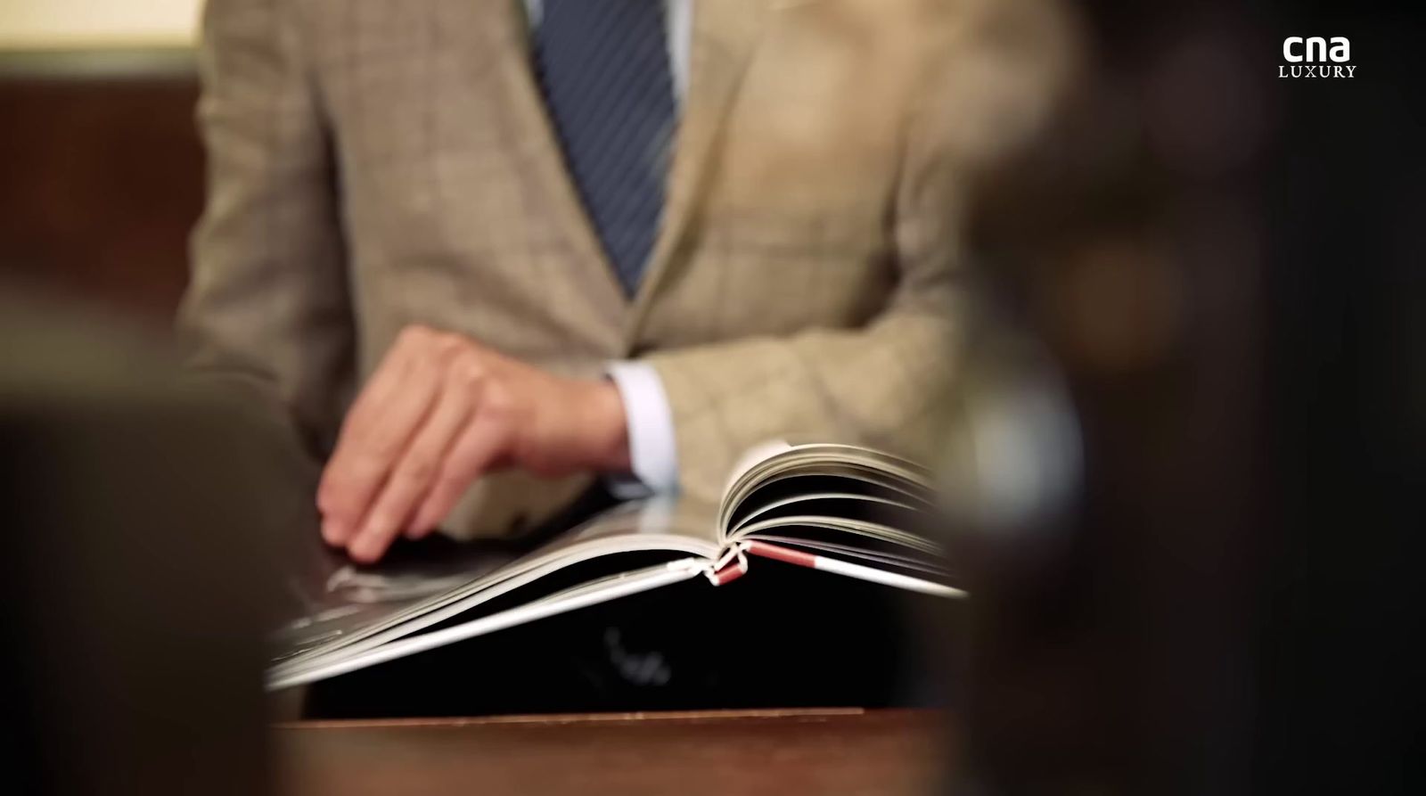 a man in a suit is reading a book